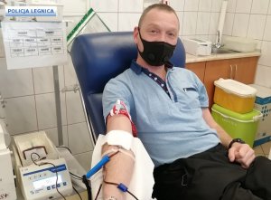 mężczyzna siedzi na kozetce w punkcie krwiodawstwa i oddaje krew
