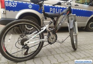 przy radiowozie policyjnym stoi rower