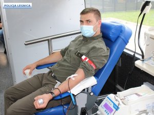 Mężczyzna siedzi na fotelu i oddaje krew.