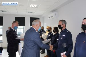 Prezydent Legnicy Tadeusz Krzakowski podaje rękę funkcjonariuszowi.