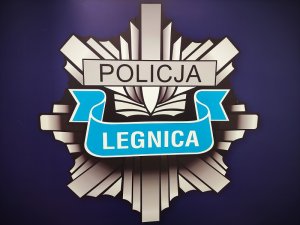 Logo Komendy Miejskiej Policji w Legnicy w postaci identyfikatora policyjnego.