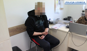 Zatrzymany w kajdankach na rękach trzymanych z przodu podczas przesłuchania