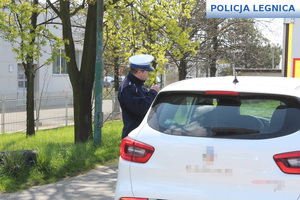 policjant ruchu drogowego kontrolujący samochód