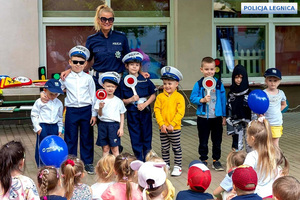 Policjantka z przedszkolakami podczas spotkania na temat bezpieczeństwa na drodze i podczas zabaw