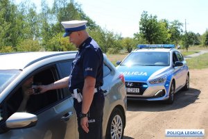 policjant bada alkomatem kierującą pojazdem