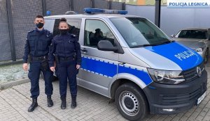 policjant z policjantką stoją przy radiowozie