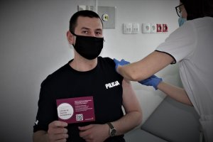 policjant w trakcie szczepienia