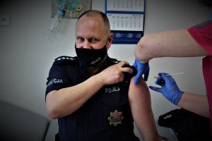 policjant w trakcie szczepienia