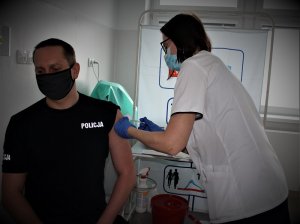 policjant w trakcie szczepienia